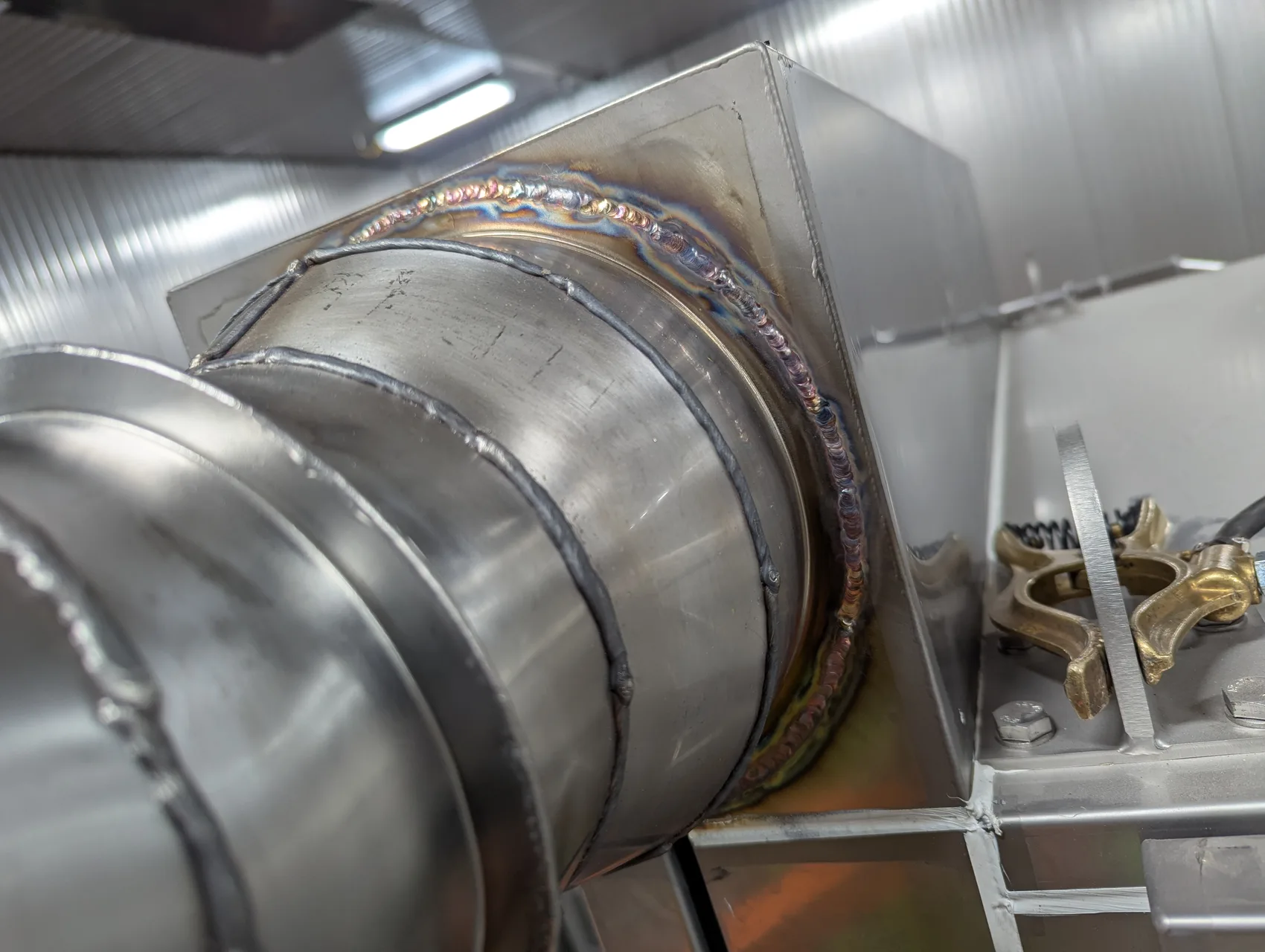Sanitary TIG weld on a round-to-square stainless transition - clean heat tint, food-grade GTAW.
