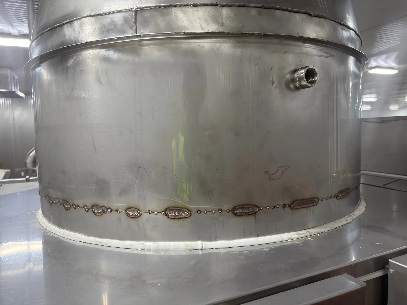 A TIG-welded seam closing out a large stainless food-grade vessel - sealed clean and ready to wipe down.
