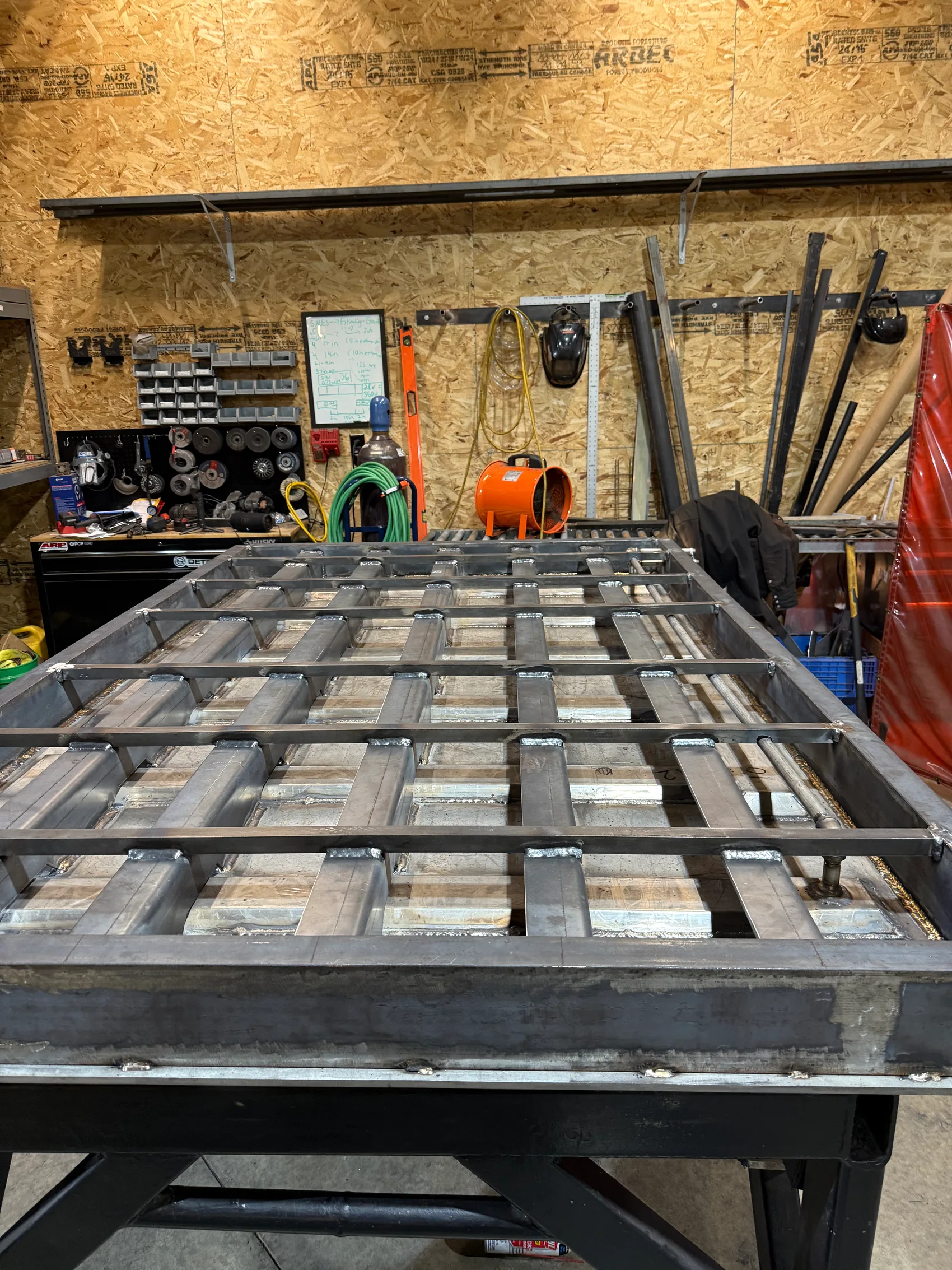 Top-down view of a steel door's internal welded grid of water-tight heater channels before skinning