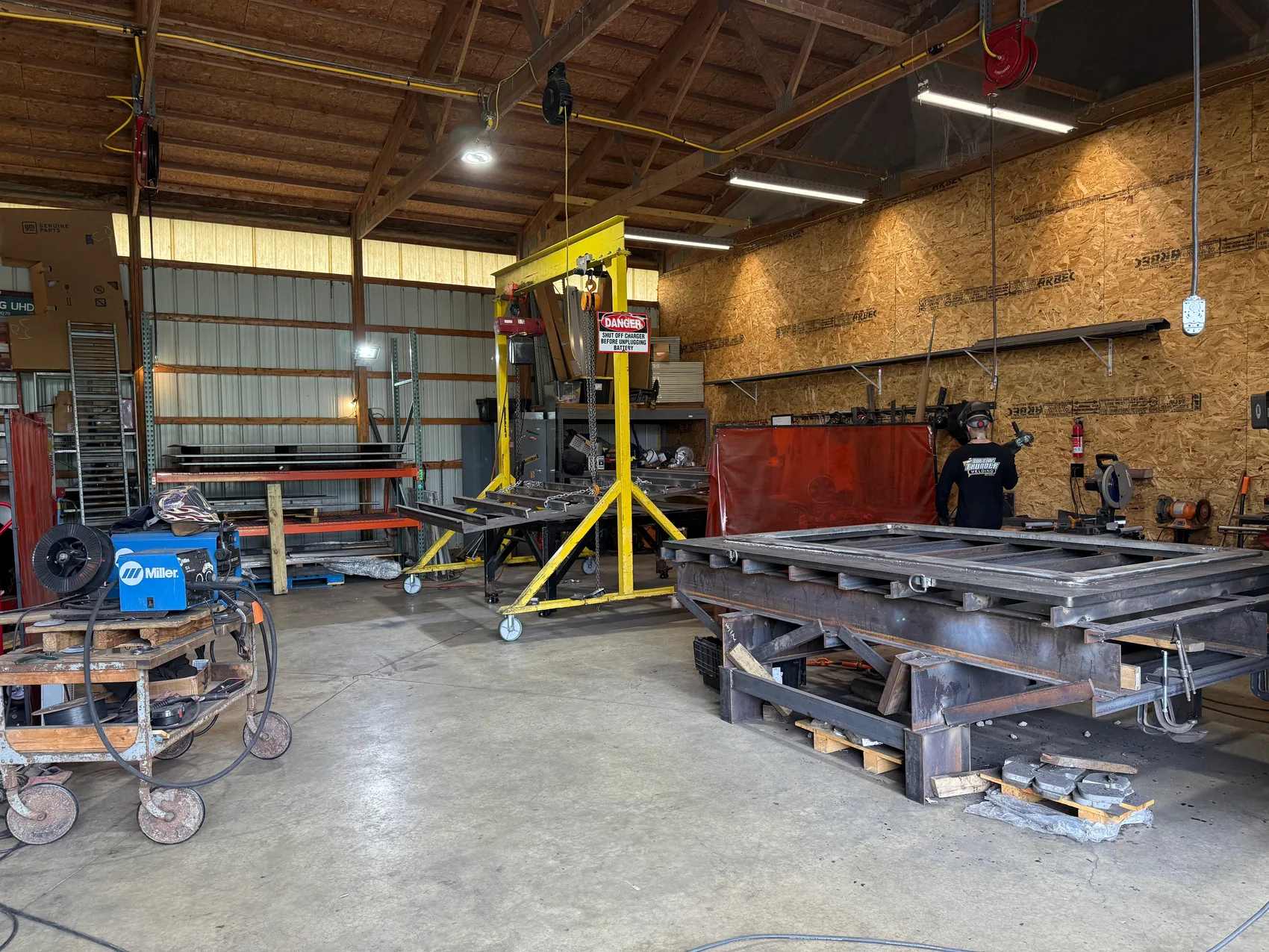 The fabrication shop: gantry, Miller welder, steel racks