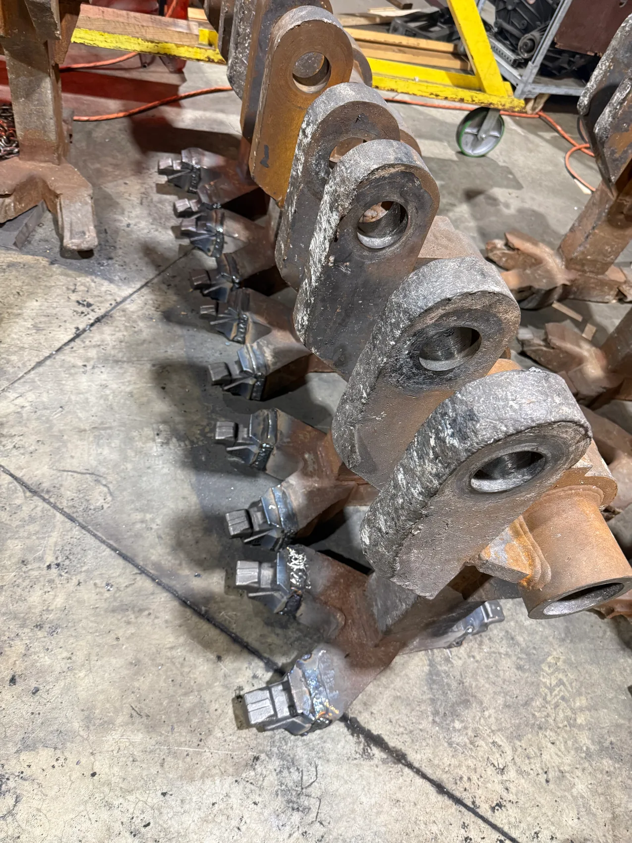 Forged drive links with welded cast teeth