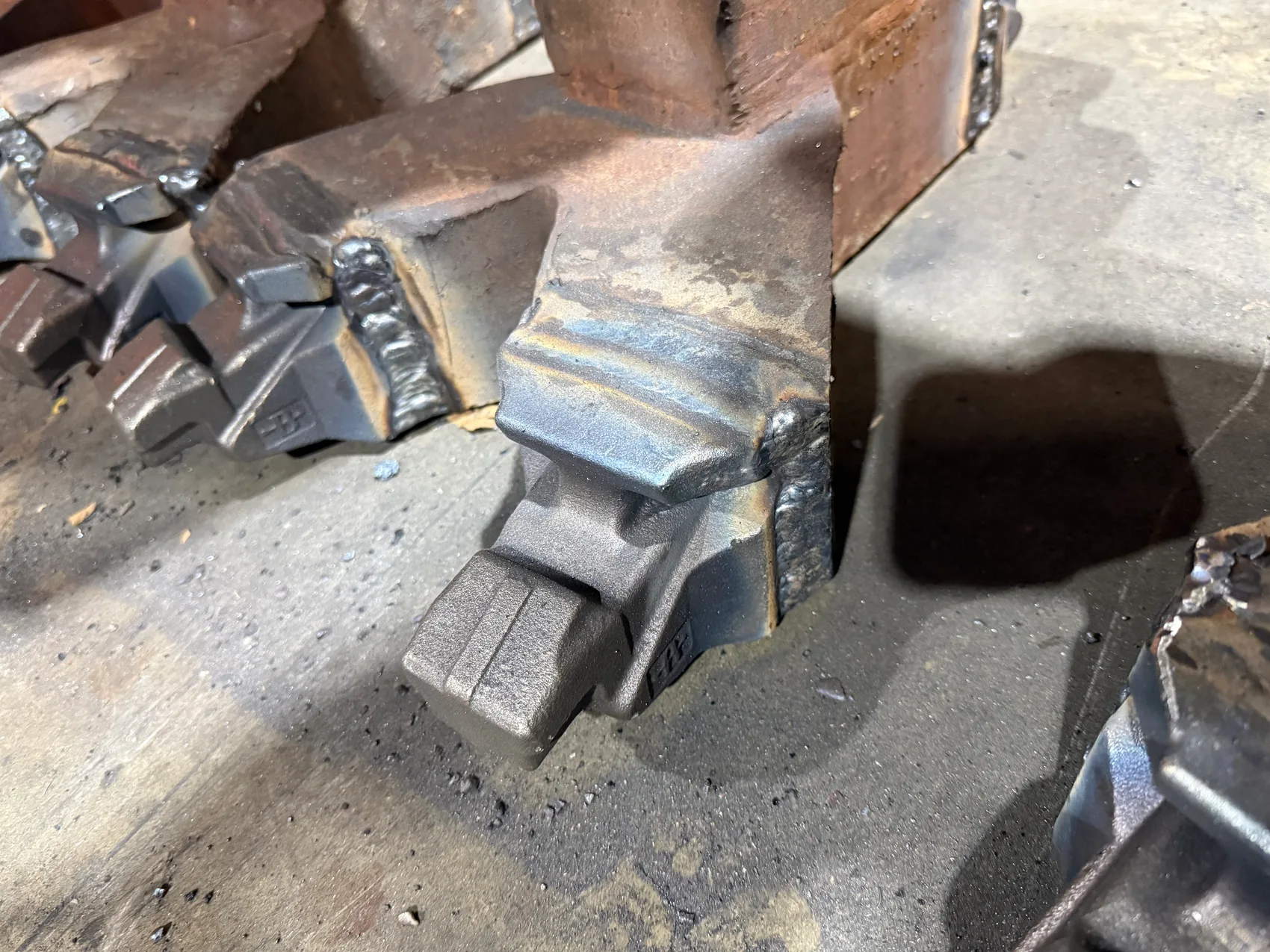 Cast teeth welded onto forged links