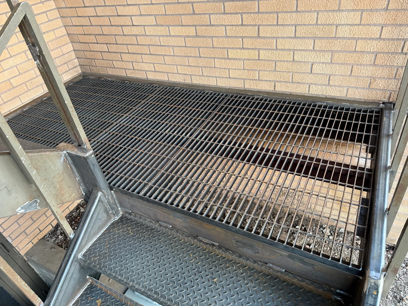 Welded steel grating landing on the new stair